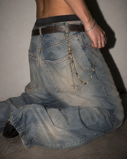 ADRN 02 Circle Gold pants chain worn laterally on oversized washed denim in a kneeling campaign shot