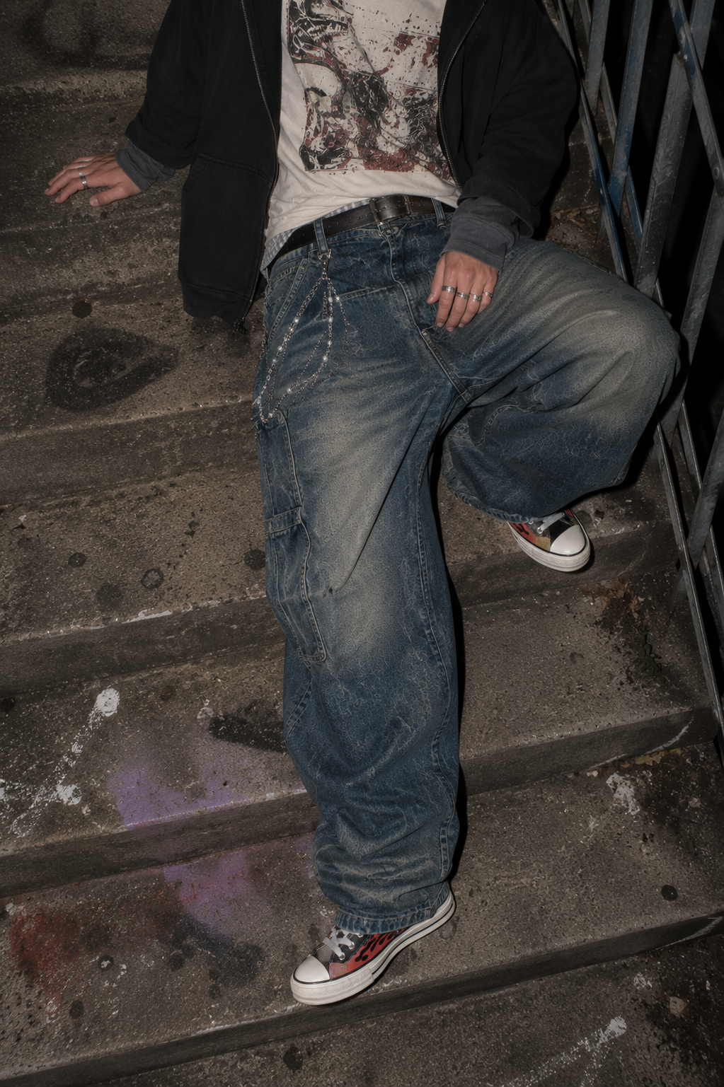 ADRN 03 Flower Silver pants chain styled with oversized washed denim while seated on raw concrete stairs